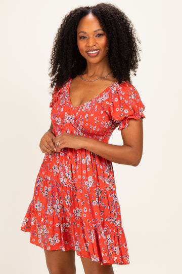 woman wearing a vibrant red floral print short dress with puff sleeves and a tiered skirt