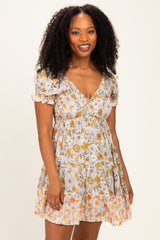 woman wearing a floral print short sleeve dress with a v-neck and ruffled hem in light colors