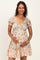 woman wearing a floral print maternity dress with short puff sleeves and a gathered waist, holding her baby bump