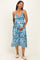 woman wearing a blue floral maternity dress with a twist front and holding her baby bump