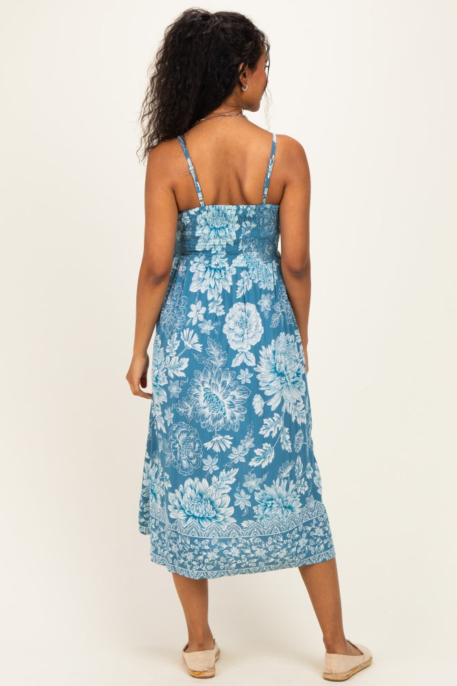 woman wearing a blue floral maternity maxi dress with adjustable straps and a ruched bodice, showing her back