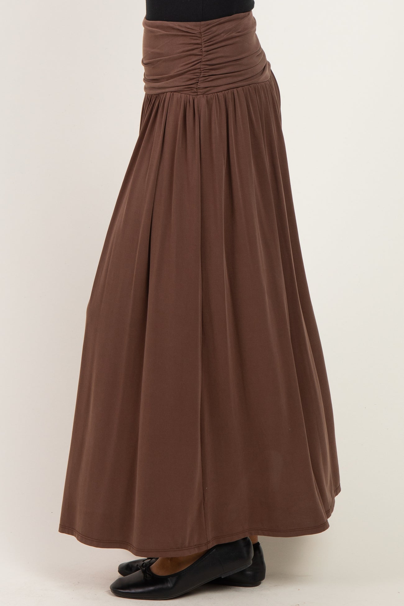 woman wearing a brown maxi skirt with a gathered waist and flowy silhouette