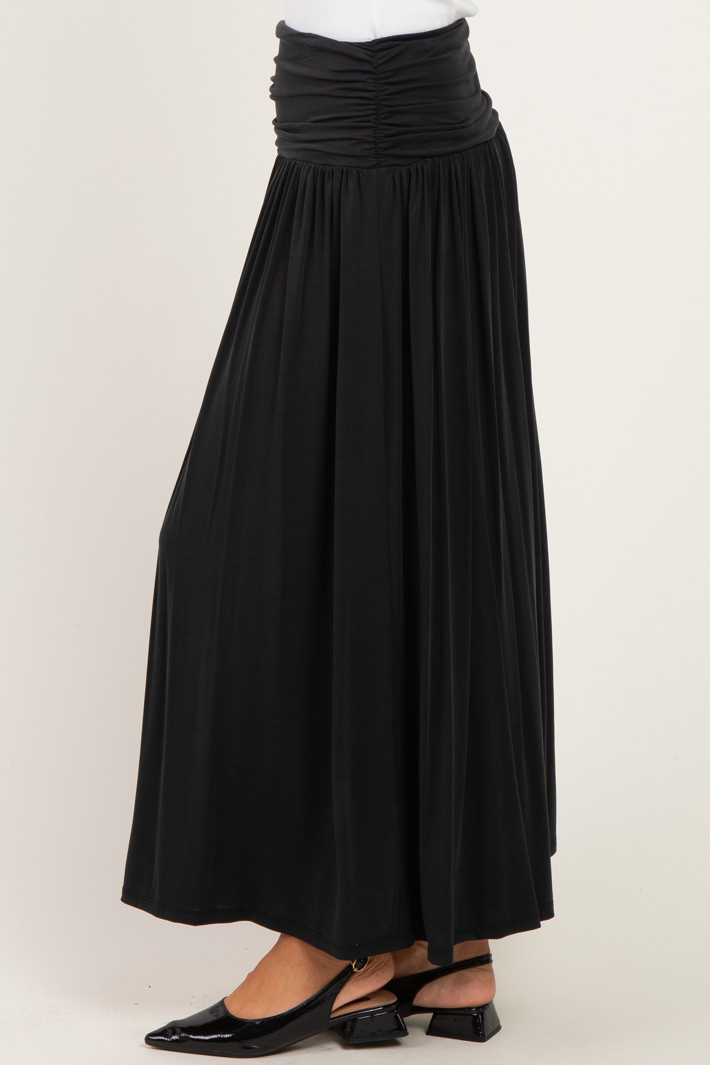 woman wearing a black maxi skirt with a ruched waistband and flowy silhouette