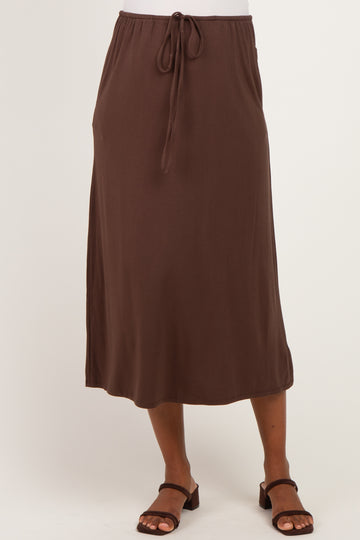 woman wearing a brown maternity maxi skirt with a drawstring waist and a relaxed fit