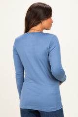 woman wearing a long sleeve maternity top in light blue, viewing from the back