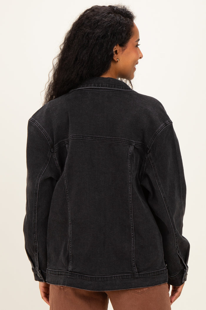 woman wearing a black denim maternity jacket, shown from the back with loose fit and dropped shoulders