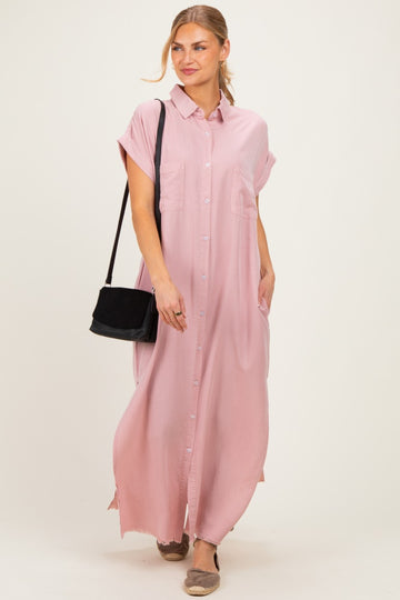 woman wearing a pink button-up maxi shirt dress with short sleeves and two front pockets, carrying a black bag