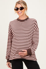 woman wearing a brown and pink striped maternity top with a visible baby bump and sunglasses