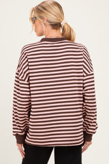 woman wearing a brown and light pink striped maternity sweatshirt, view from the back, with a ponytail hairstyle