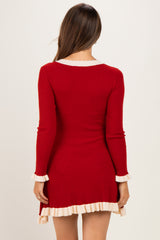 woman wearing a red ribbed maternity dress with cream ruffle trim and long sleeves