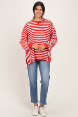woman wearing a red and white striped oversized sweater with red cuffs and blue jeans