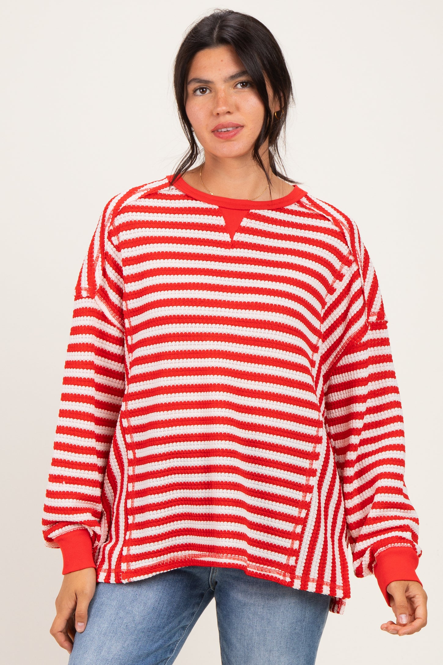 woman wearing a red and white striped oversized sweatshirt with a relaxed fit and long sleeves