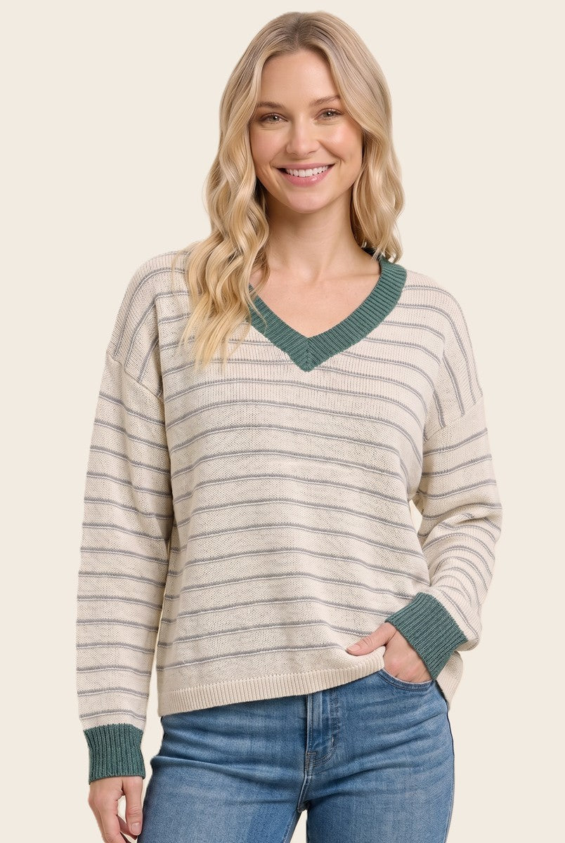 woman wearing a cream and green striped v-neck sweater with a relaxed fit and long sleeves