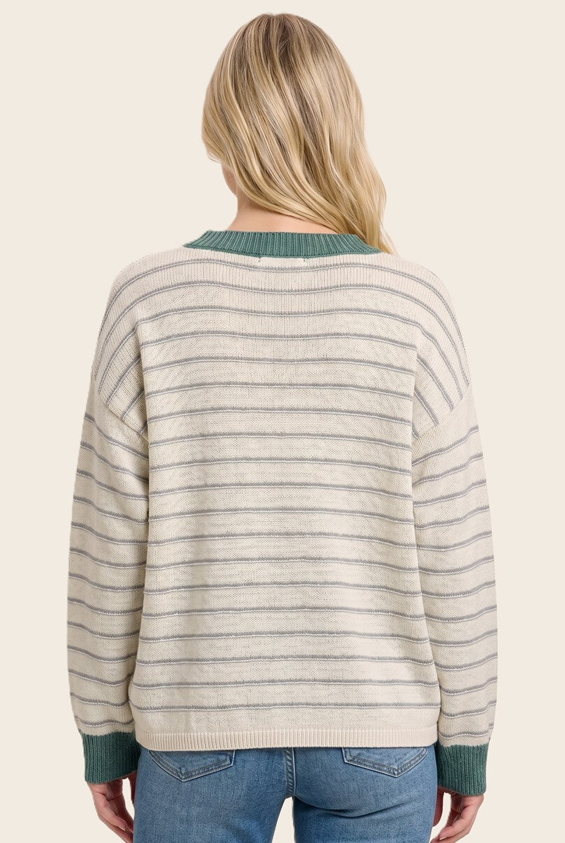 woman wearing a cream and gray striped oversized sweater with a green collar, showing the back view