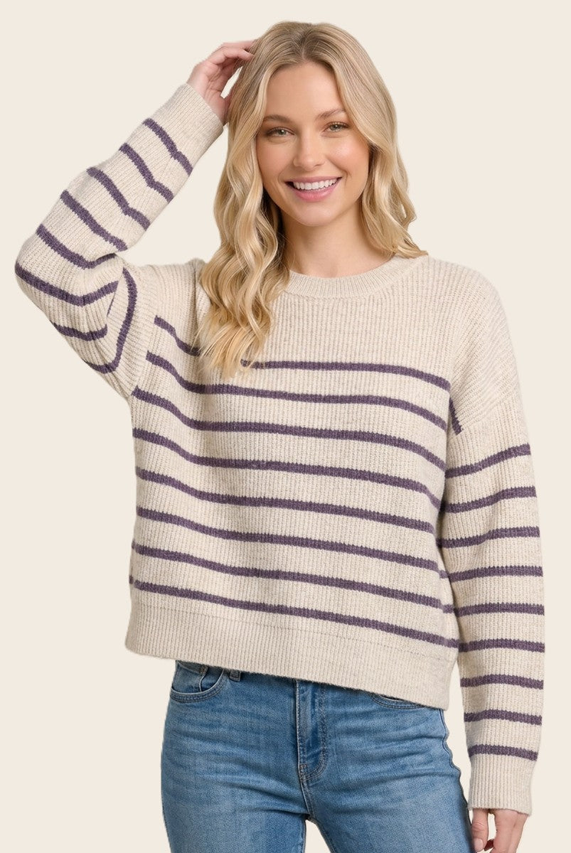 woman wearing a cream and purple striped knit sweater with a relaxed fit and long sleeves