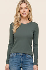 woman wearing a green long sleeve ribbed top with a round neckline and casual jeans