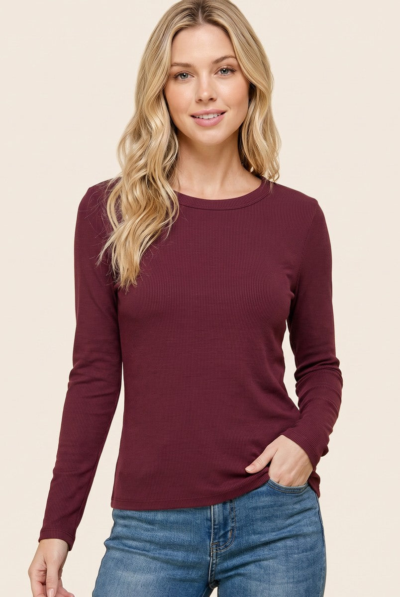 woman wearing a burgundy long sleeve ribbed top and blue jeans