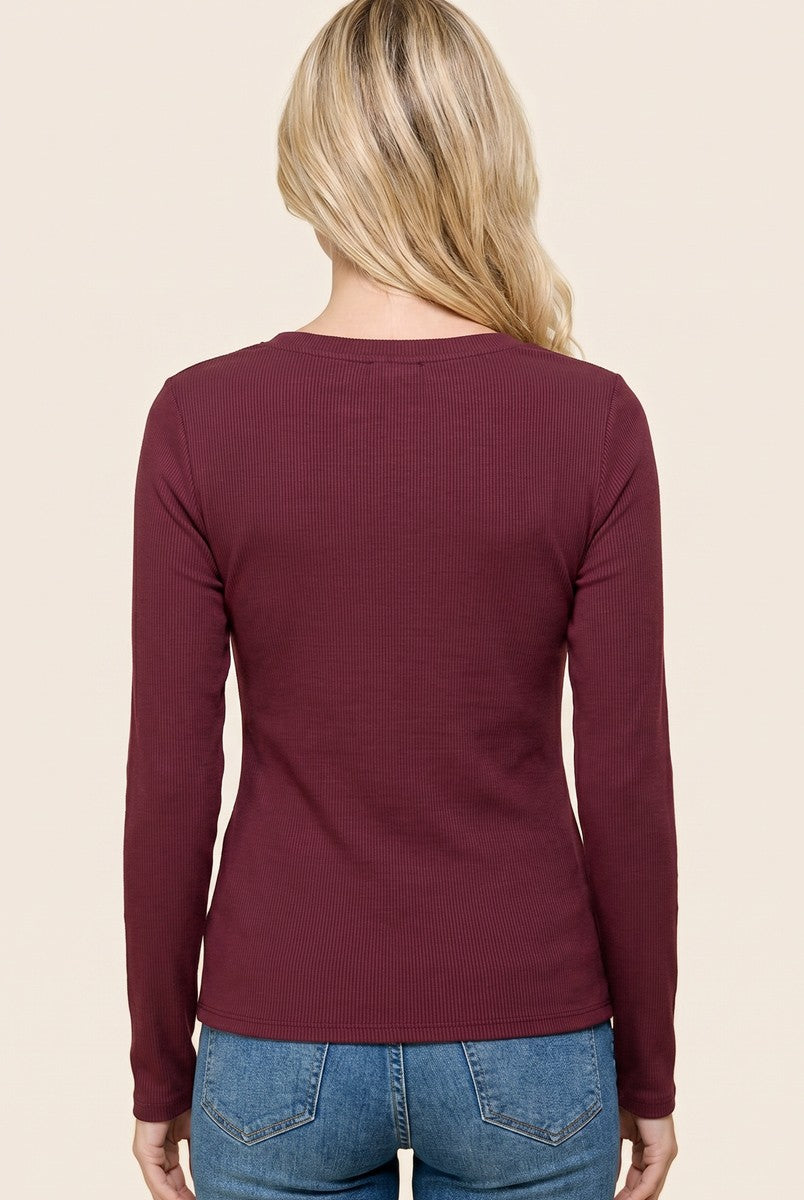 woman wearing a burgundy long sleeve ribbed top, viewed from the back, paired with light blue denim jeans