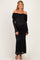 woman wearing a black off-the-shoulder lace maternity dress with long sleeves and a fitted silhouette, showing her baby bump