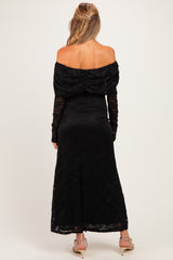 woman wearing a black off-shoulder lace maternity dress with long sleeves and a fitted bodice