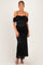 woman wearing a black lace off-the-shoulder maternity gown with a fitted silhouette and a visible baby bump