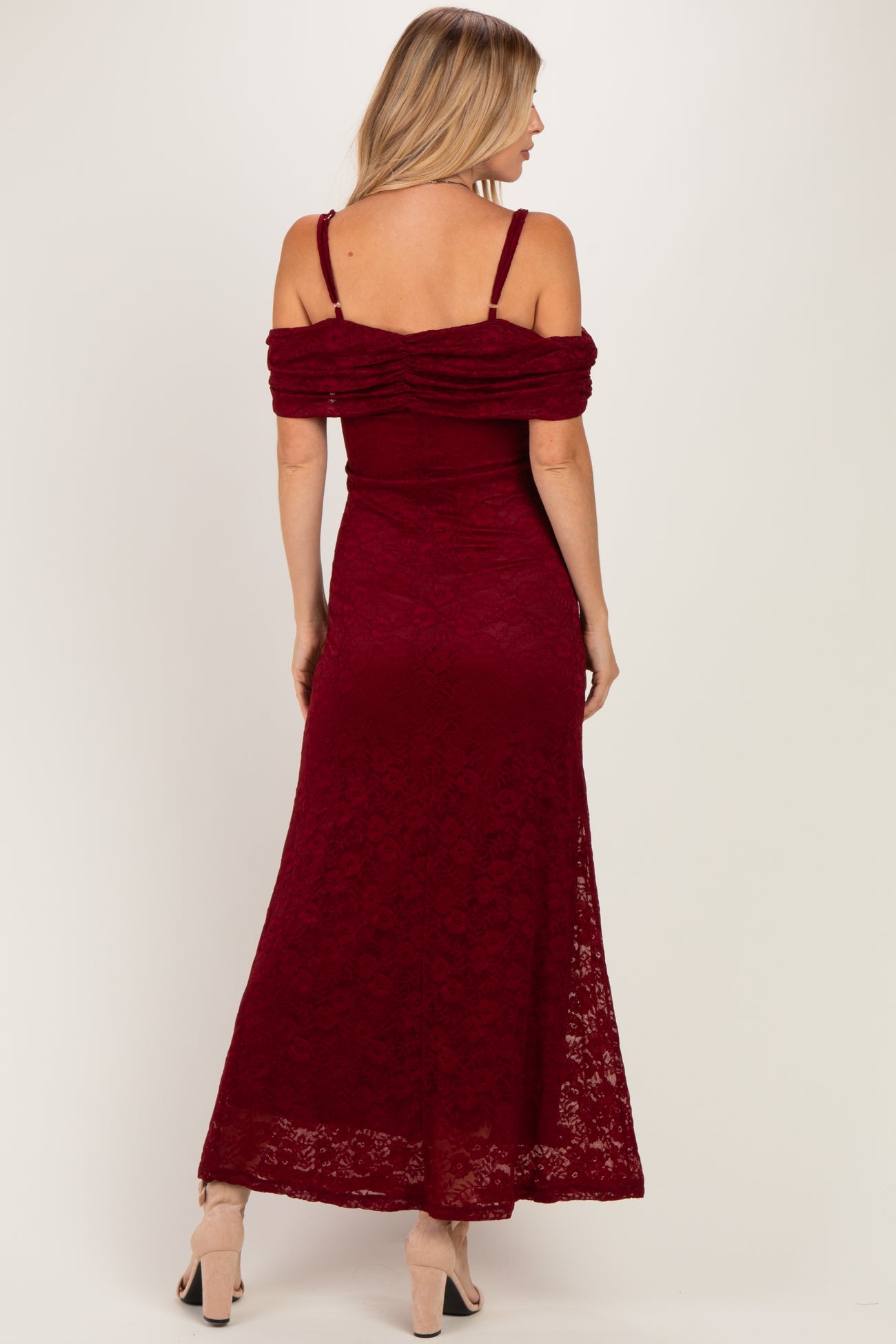 woman wearing a burgundy off-the-shoulder maxi dress with ruched detailing on the back