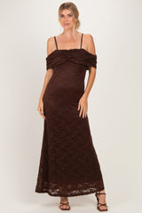 woman wearing a brown lace maxi dress with off-the-shoulder sleeves and a fitted silhouette