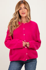 woman wearing a bright pink maternity cardigan with buttons, styled casually with jeans
