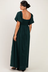 woman wearing a dark green maxi dress with puff sleeves and a smocked bodice, showing the back view