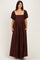 woman wearing a brown puff sleeve maxi dress with a square neckline and side pockets