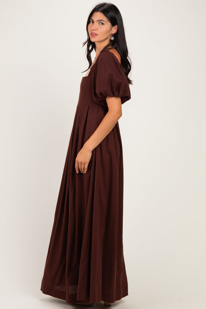 woman wearing a brown puff sleeve maxi dress with a fitted bodice and flowing skirt, shown from the side