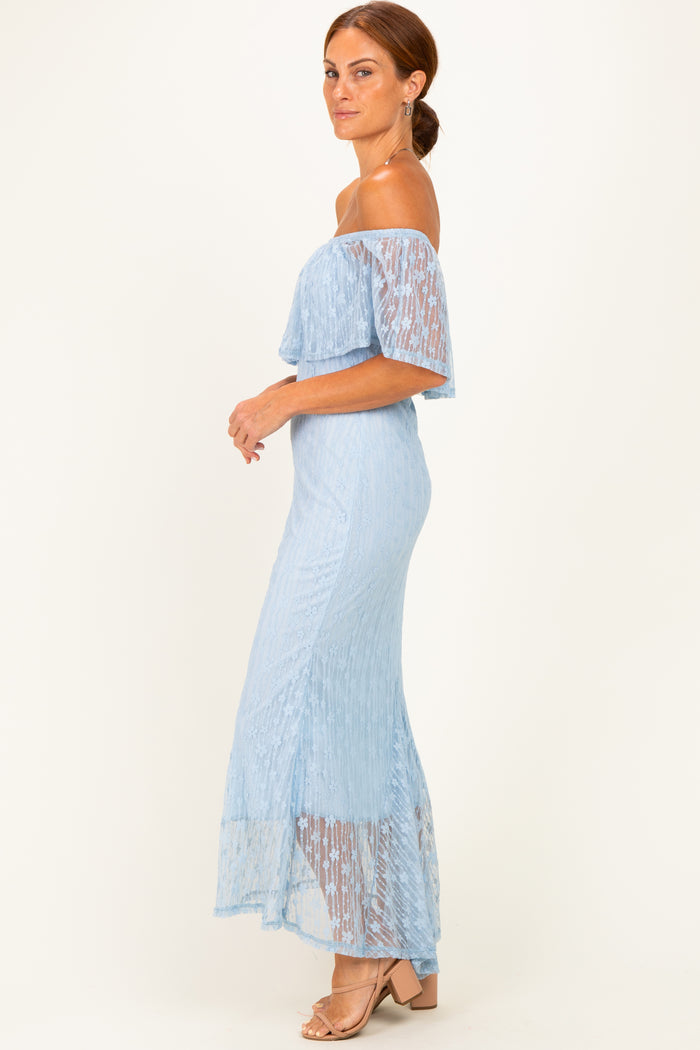 woman wearing a light blue off-shoulder maxi dress with lace details and a flowy hemline