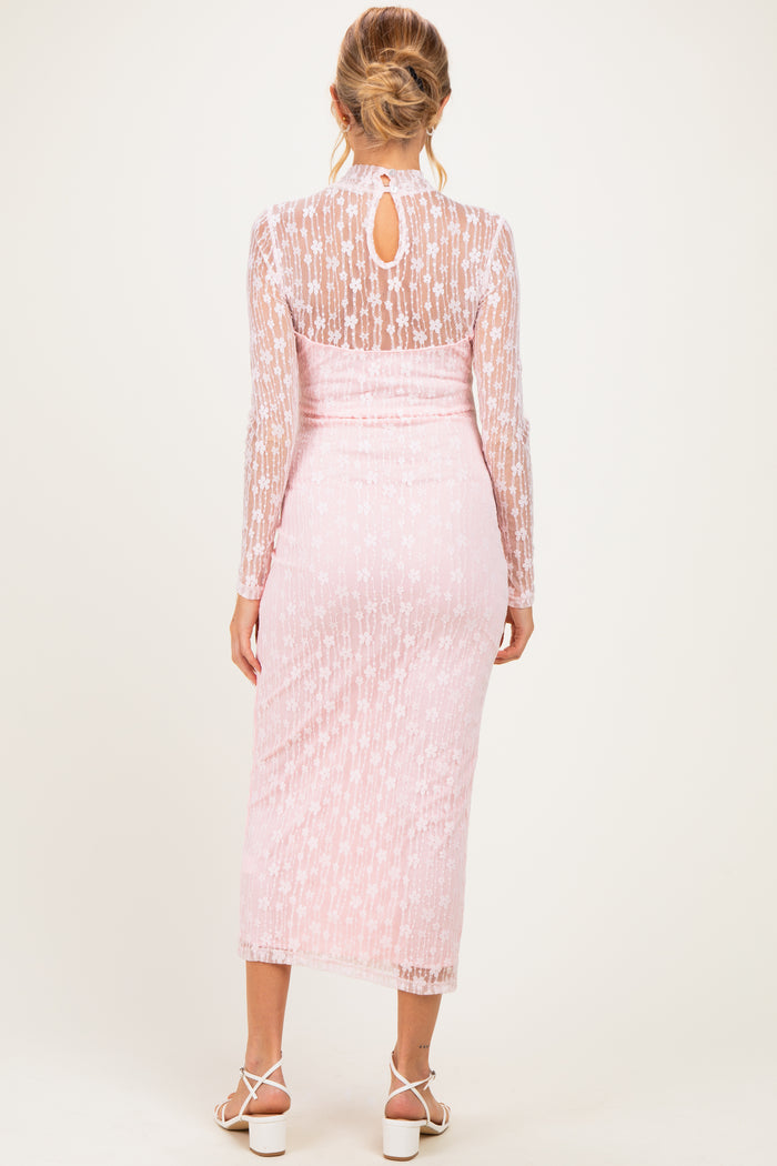 woman wearing a pink maternity lace dress with long sleeves and a keyhole back detail