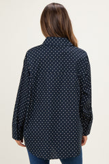 woman wearing a black and white polka dot maternity shirt with a relaxed fit, showing the back view