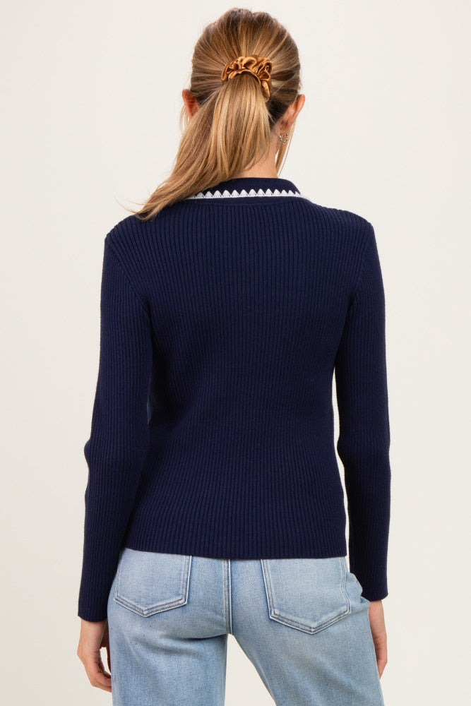 woman wearing a navy blue ribbed maternity sweater with a white scalloped collar, viewed from the back