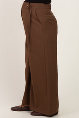 woman wearing brown maternity wide-leg pants with a drawstring waist and side pleats, no visible baby bump