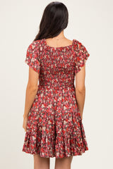 woman wearing a red floral short dress with smocked bodice and flared skirt, shown from the back