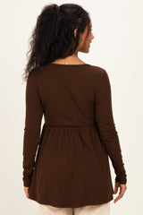 woman wearing a brown long sleeve maternity top with a peplum style and a relaxed fit from the back
