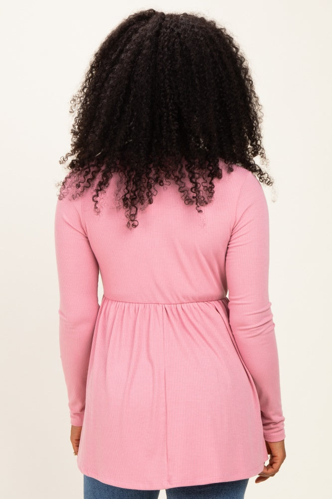 woman wearing a pink long sleeve ribbed tunic with a fitted waist and rounded hem, viewed from the back