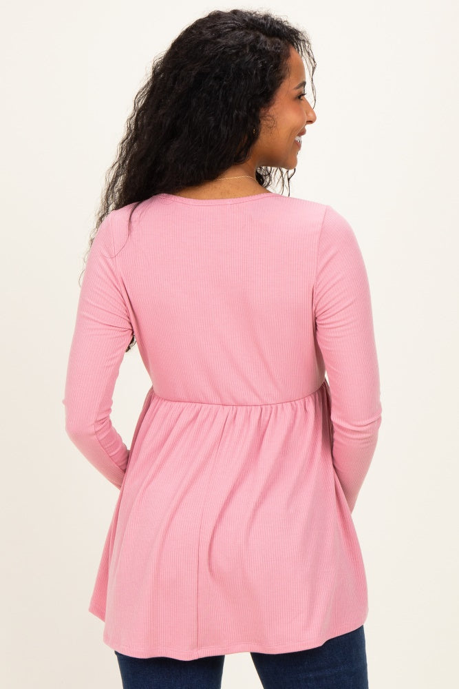 woman wearing a pink long sleeve maternity top with a gathered empire waist, seen from the back