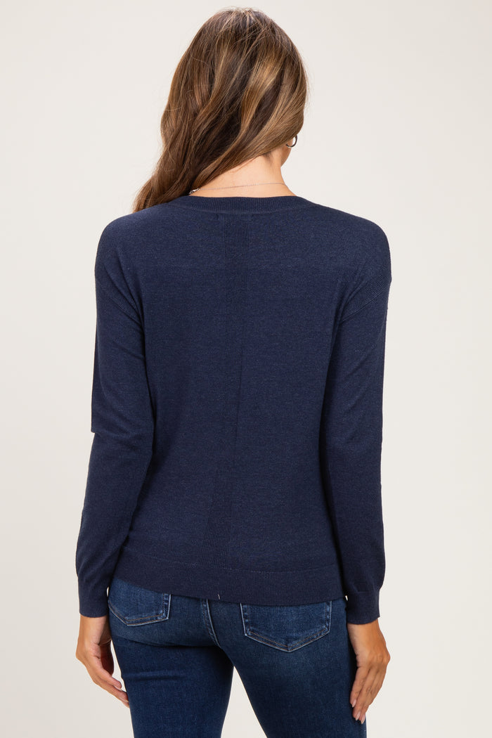 woman wearing a navy blue maternity sweater with long sleeves and a relaxed fit, seen from the back