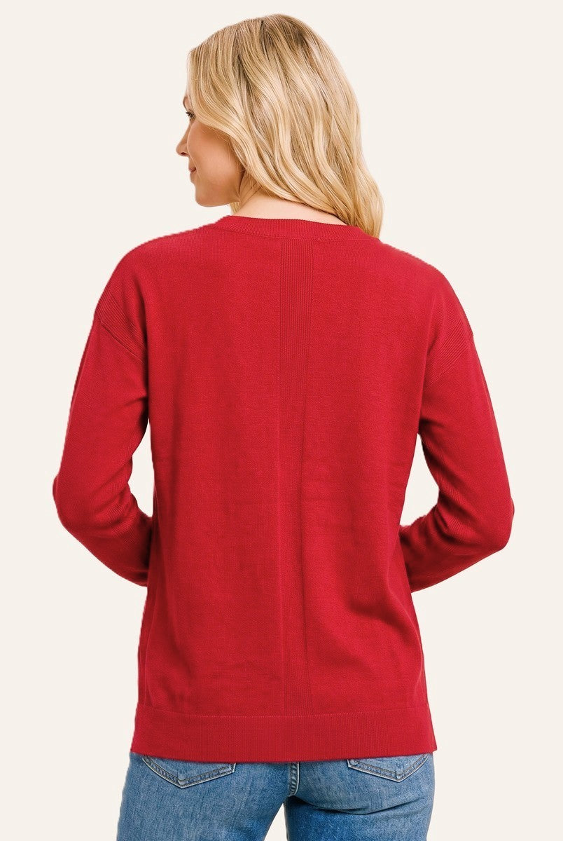 woman wearing a back view of a red long sleeve sweater with a relaxed fit and ribbed hem, paired with blue jeans
