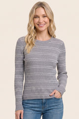 woman wearing a gray ribbed long sleeve sweater with white stripes and smiling