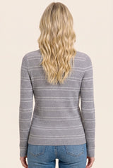 woman wearing a gray ribbed long sleeve top with white stripes, viewed from the back, paired with blue jeans