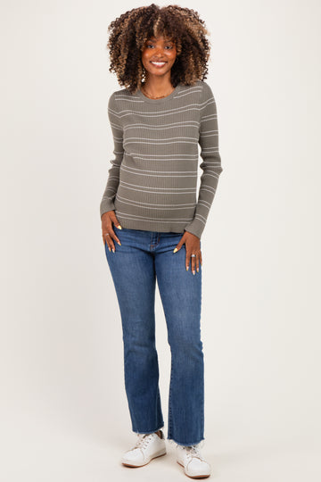 woman wearing a grey striped maternity sweater and blue jeans, showing her baby bump