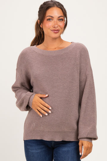 woman wearing a mauve maternity sweater with a relaxed fit and holding her baby bump