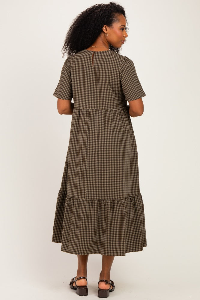 woman wearing a brown and black plaid midi dress with short sleeves and a ruffled hem, shown from the back