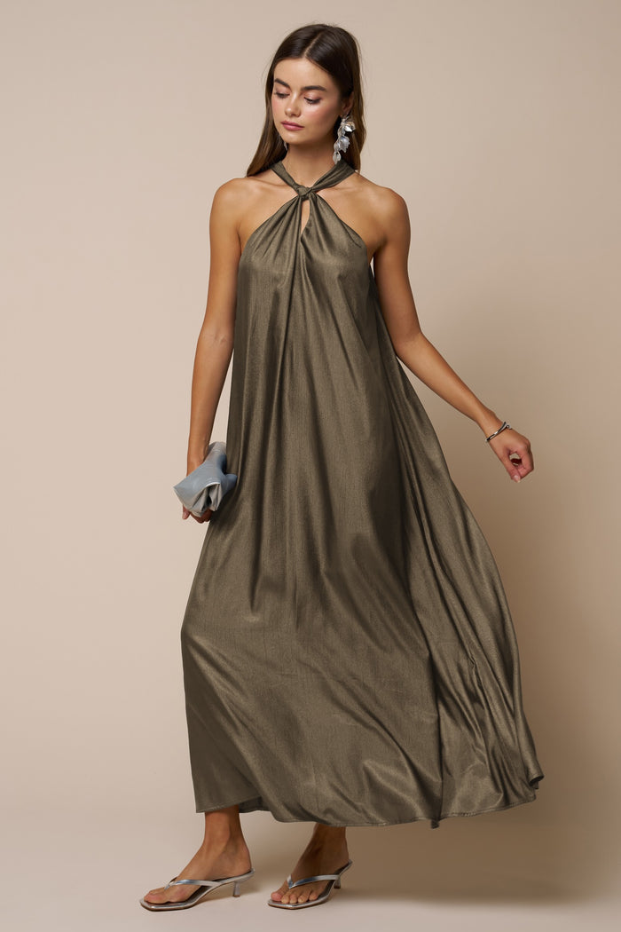 woman wearing an olive green halter neck maxi dress with a flowing silhouette and silver earrings
