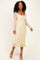 woman wearing a gold floral lace long sleeve midi dress with a square neckline and fitted silhouette