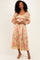 woman wearing a beige floral midi dress with puff sleeves and a square neckline